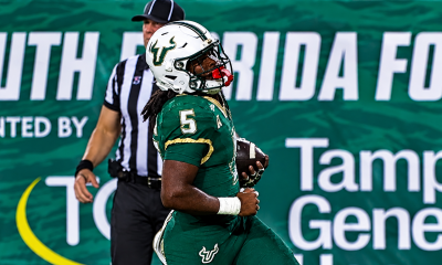 USF Bulls football player No. 5 holds the football and celebrates on the field at Raymond James Stadium in Tampa.