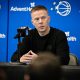 Orlando Magic coach Sean Sweeney speaks into a microphone at a press table against a blue backdrop featuring Magic and AdventHealth logos.
