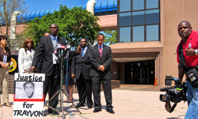 FCRA representatives address reporters beside a “Justice for Trayvon” sign outside Florida’s regional offices in Orlando.